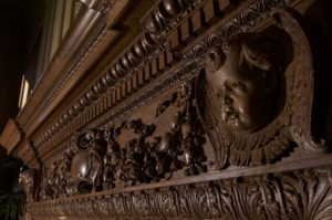 Detail of the carved wood fireplace mantel of Holmes Lounge.