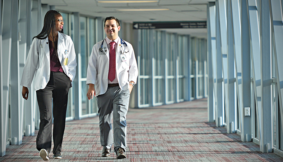a male and a female physicians walking