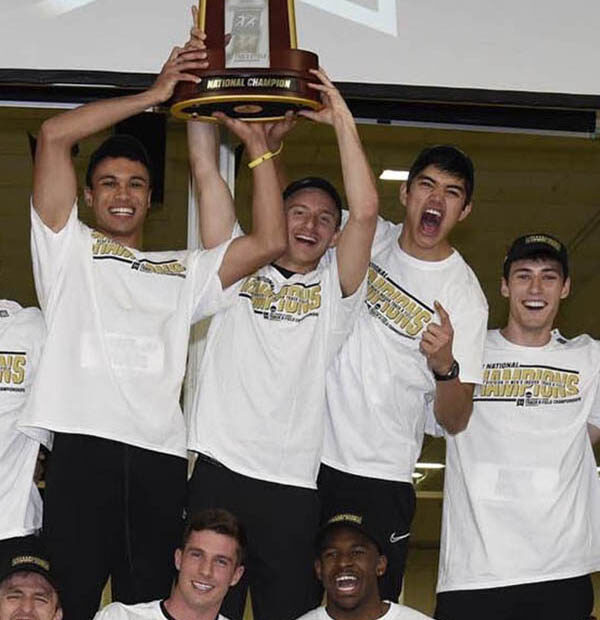 The men's track and field team holds up trophy