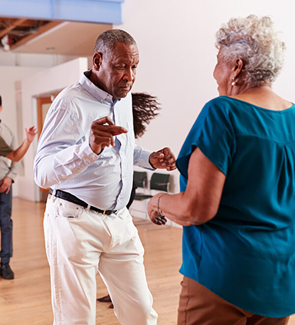 An older African American man dancing with an older African American woman